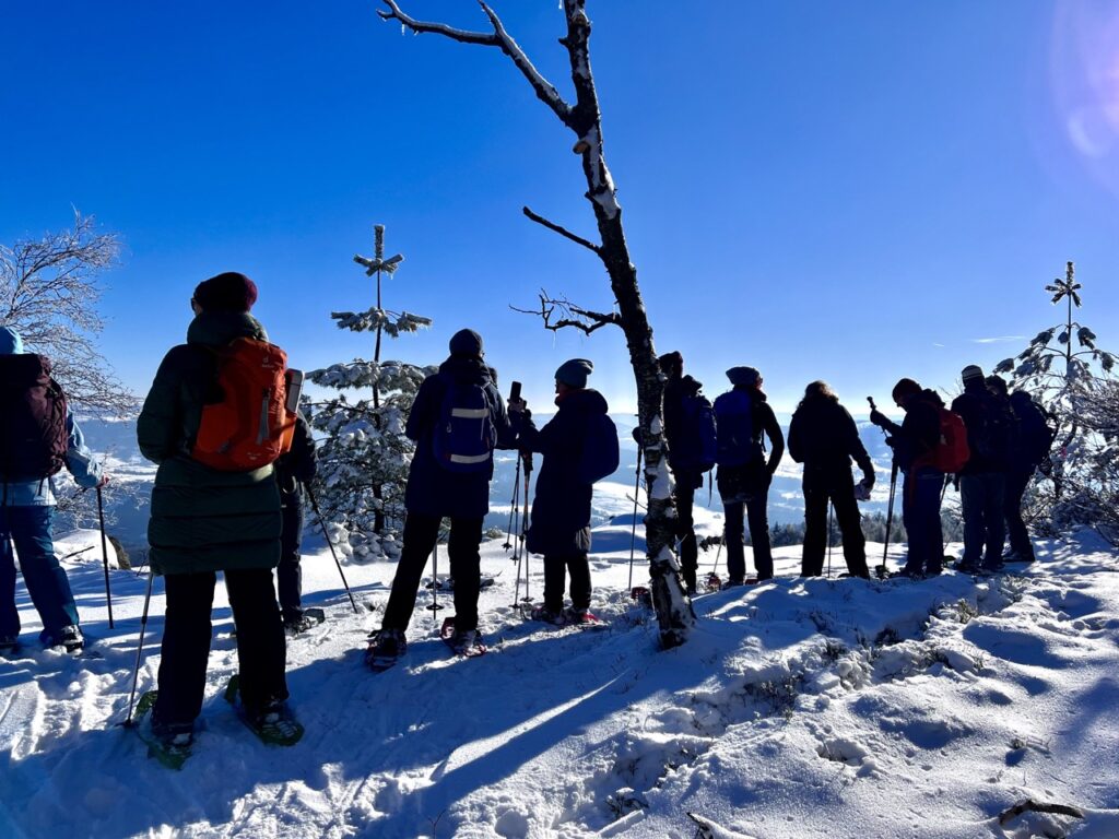 Schneeschuhwanderer genießen die Aussicht vom Schneeberg